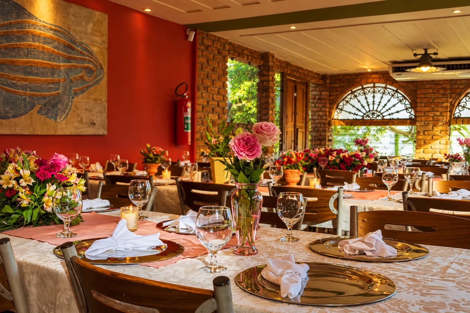 Salão do Buzin preparado para eventos, com mesas decoradas e arranjos florais.