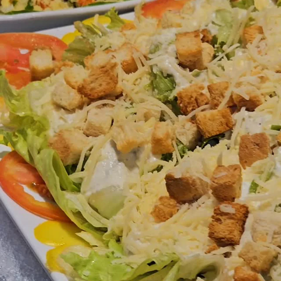 Salada servida com folhas, tomate, queijo e croutons.